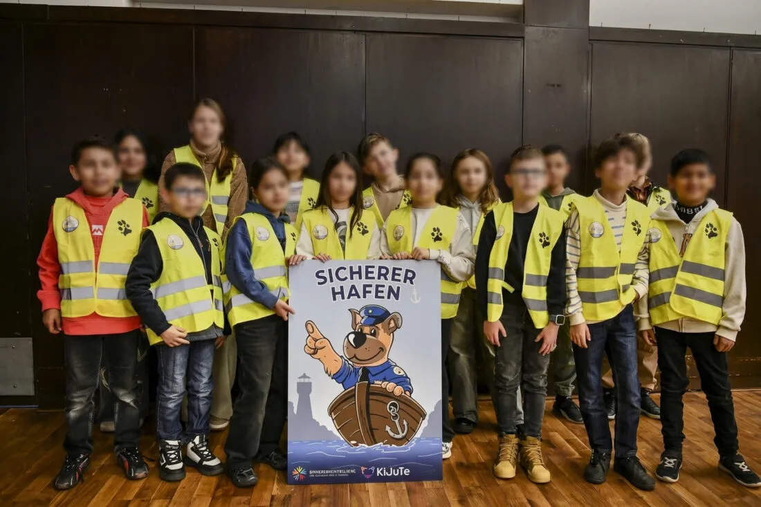 Kinder in Warnwesten mit dem Plakat Sicherer Hafen