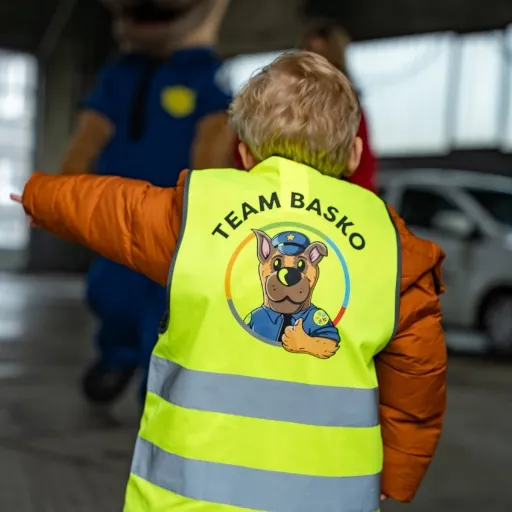 Kind in Warnweste mit Aufdruck Team Basko